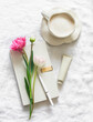 A cup of coffee, a personal diary, hand cream, tulips on a light background, top view
