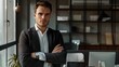 © Jeerawut - confident businessman with a sharp stare, leaning against a desk in a well-lit office in the most popular stock photo company.