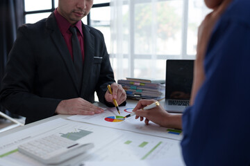 Wall Mural - Team of business people working at office. Analyzing, discussing and recording financial budget results, investments, project plans, business operations based on graph documents. chart into laptop.