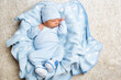 Baby Boy in Blue Clothes sleeping on Blanket. Cute Newborn sleep on Back over Fluffy Carpet. Infant Clothes. Baby Birth and Health Care