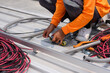 Close-up of a worker installing solar panels. A worker installs solar panels at a solar farm field.