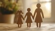 © Maxim Borbut - Concept of family care. Hands on table with paper silhouettes.