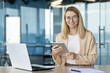 © Tetiana - Professional businesswoman using tablet in modern office