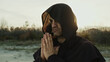 Religious Monk Wears His Hood And Prays In Nature At Sunset