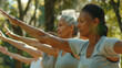 Group of adults extending their arms in unison while practicing Tai Chi outdoors.