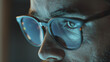Intense focus emanates from a man's eye, magnified behind stylish glasses.