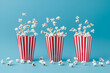 Fluffy popcorn in red strip paper bucket on blue background. Copy space for text. Cinema and movie theater concept	
