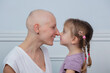 Strong woman and mother fight cancer touch noses with daughter