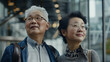 A candid portrait of an elderly married Asian couple. Two old people with glasses are standing next to each other