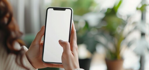 Close up woman hand holding blank white smartphone empty screen in living room home.