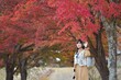 Asian woman in casual dress embraces the beauty of Japan's autumn. A holiday portrait capturing friends, selfies, and joyful moments by the lake near Mount Fuji.