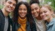 © polack - Four smiling happy multiethnic friends in against a heavily blurred park background