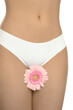 © New Africa - Gynecology. Woman in underwear with gerbera flower on white background, closeup