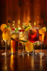 Wall Mural - A row of drinks on a bar counter, including a pink drink with a lime wedge