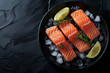 A plate of salmon and lemon slices on a black background