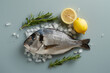 A fish is on a table with a lemon and some herbs