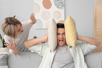 Poster - Young man with pillows stressed of his noisy son at home