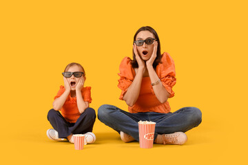 Poster - Beautiful mother and her cute little daughter in 3D glasses with buckets of popcorn on yellow background