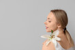 © Pixel-Shot - Beautiful young woman with lily flower on grey background