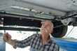 male senior working underneath a lifted car