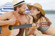 beautiful young people with guitar on beach