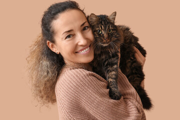 Wall Mural - Happy mature woman with cute cat on brown background