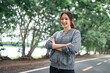 Asian woman in hoodie running sport exercises outdoors on a background of park trees on springtime. Healthy lifestyle well being wellness happiness concept