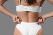 © Pixel-Shot - Young woman in white underwear on grey background, back view