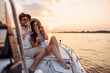 Couple drinking champagne while sailing to the sunset on a boat