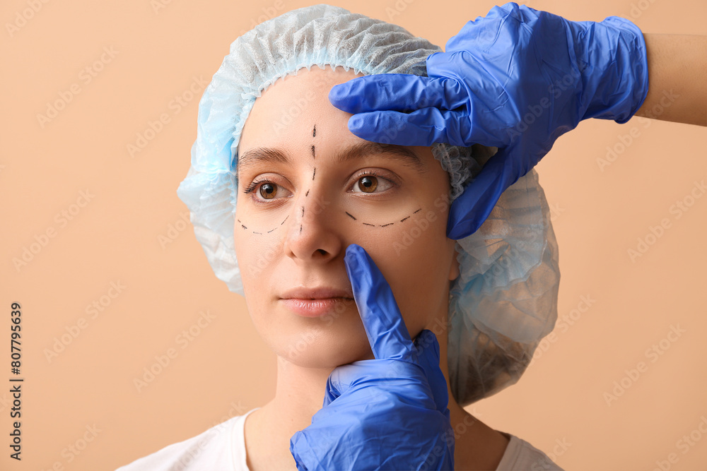Plastic surgeon examining woman's face on brown background. Blepharoplasty concept