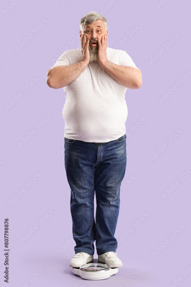 Overweight shocked mature man with scales on purple background. Weight loss concept