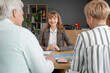 © Pixel-Shot - Female travel agent working with mature couple at table in office