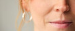 Close Up Studio Shot Of Woman's Mouth Looking At Camera Against Plain Studio Background
