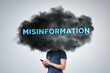© photoschmidt - Dark Cloud Labeled 'Misinformation' Hovering Over a Person's Head