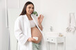 © Pixel-Shot - Young pregnant woman with jar of cream in bathroom