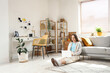 © Pixel-Shot - Young pretty woman sitting on floor and using modern laptop in light living room