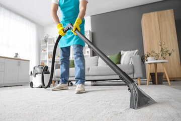 Poster - Male janitor cleaning carpet in room