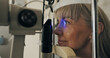 © peopleimages.com - Mature woman, slit lamp and face for eye test or medical service with optometry technology. Eyeball, led light or patient with assessment for healthcare with lens for vision and ophthalmology
