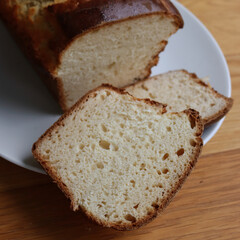 Homemade baked and sliced  Brioche Bread on a white plate on wooden table