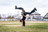 Fototapeta Przestrzenne - Teenage girl with cat mask and gloves doing Quadrobics. girl in a cat mask Jumps like a cat. the athlete is standing on her hands