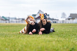 Fototapeta Przestrzenne - Teenage girls with cat mask and gloves doing Quadrobics. girls in a cat mask is lying on the grass.