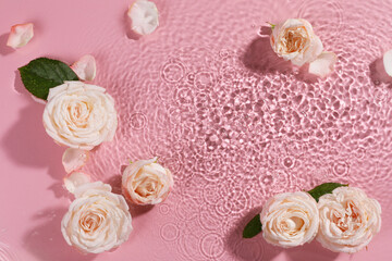 Poster - Beautiful roses, petals and leaves in water on pink background, top view. Space for text