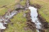 Fototapeta Młodzieżowe - Rural dirt road with puddles and mud, spring, thawing.