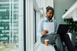 © Drazen - Happy black businessman working on laptop in office.