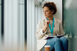 © Drazen - Pensive businesswoman looking through the window in office.