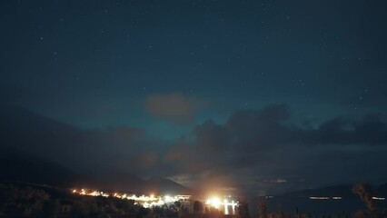 Wall Mural - Night skies lit by the northern lights above the brightly illuminated port and the dark fjord.