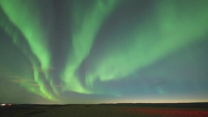 Wall Mural - The captivating dance of the Aurora Borealis in the winter sky illuminates the dark waters of the fjord.