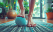Close-up photo of woman's feet as she massages herself using rubber ball after yoga exercises. This image embodies concepts of healthy lifestyle, active individuals, motivation, and self-improvement