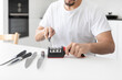 © Vitaliy - Close-up photo of man sharpening knives with special knife sharpener at home