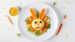 Funny food for children, cute bunnies with vegetables on a plate on a white background, an emotional character with eyes